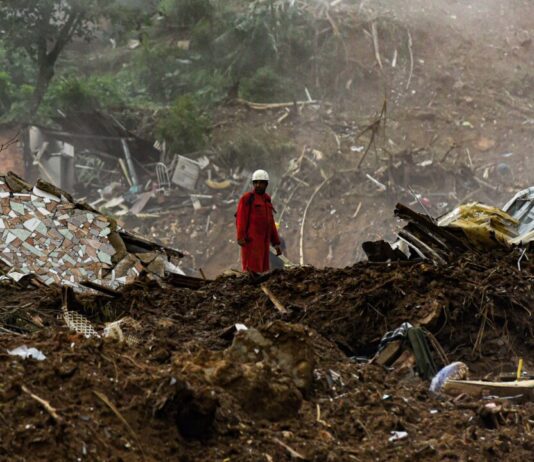 Bomberos y personal de defensa civil buscan a víctimas enterradas por las inundaciones y los deslizamientos de tierra en febrero de 2022 en el municipio de Petropolis, Río de Janeiro, Brasil (Imagen: Alamy)