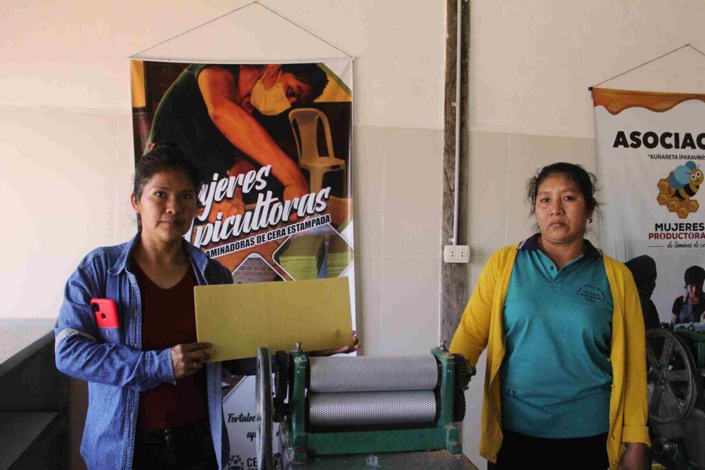 Mercy Arapino y Estela Cuevas exhiben láminas de cera producidas en Chimeo, parte de la apicultura comunitaria.