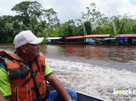 El líder indígena Lucio Ayala Siripi, presidente del TIM II, observa balsas mineras asentadas en el río Madre de Dios durante la inspección del Tribunal Agroambiental.
