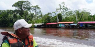 El líder indígena Lucio Ayala Siripi, presidente del TIM II, observa balsas mineras asentadas en el río Madre de Dios durante la inspección del Tribunal Agroambiental.